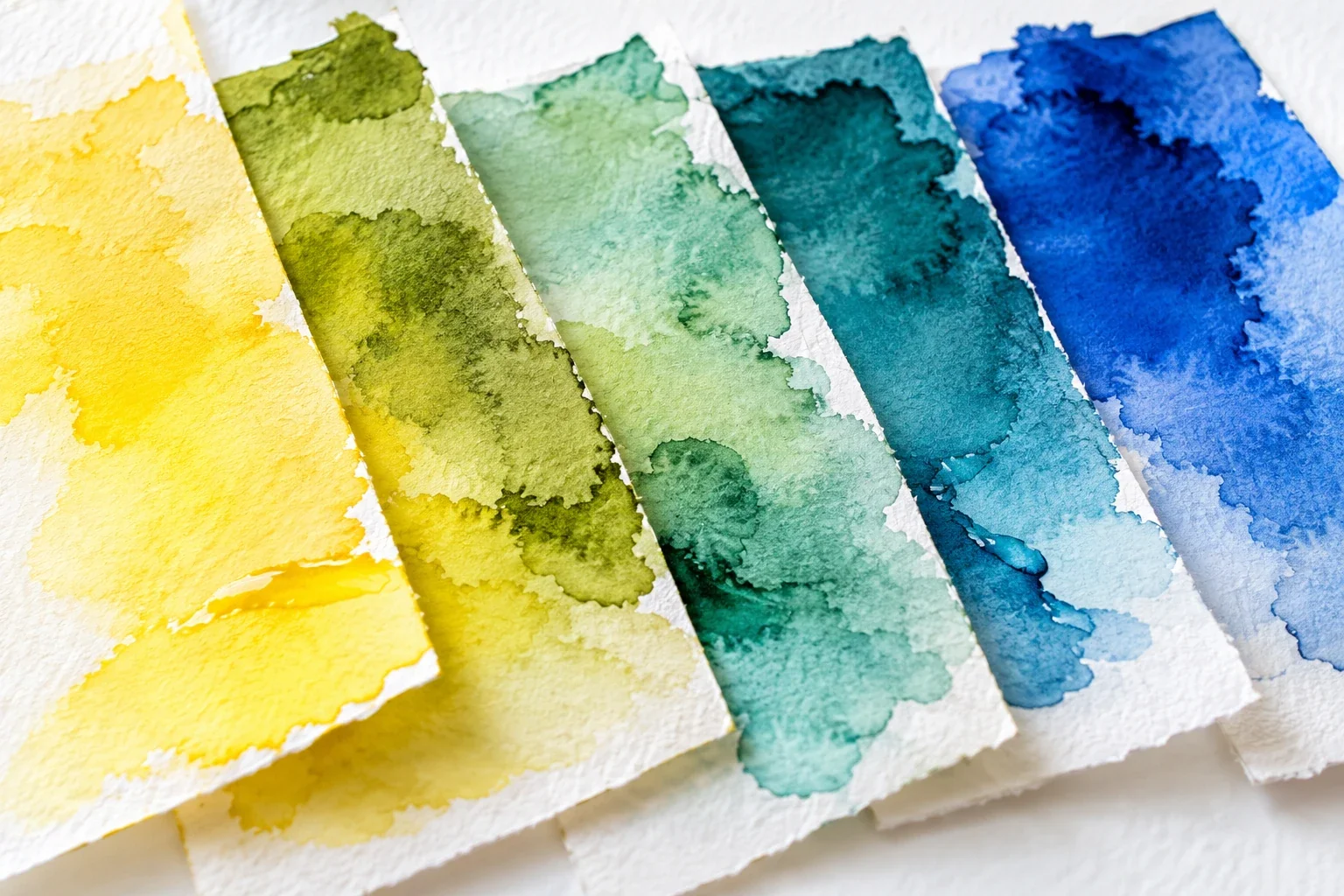 Translucent yellow-to-blue mixing swatches on textured paper